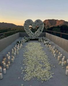 a long table with flowers and candles on it in the shape of a heart is shown