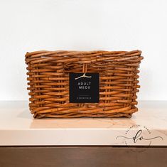 a wicker basket sitting on top of a counter with a tag hanging from it