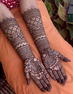 two hands with henna designs on them