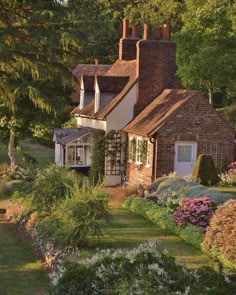 the house is surrounded by beautiful flowers and greenery