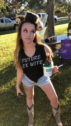 a woman in cowboy boots holding a coffee cup and some kind of substance on her hand