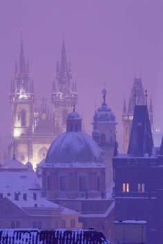 an image of a city skyline in the snow at night with buildings and spires lit up