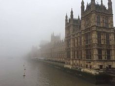 the big ben clock tower towering over the city of london on a foggy day