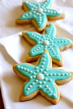 three decorated starfish cookies sitting on top of a white napkin next to each other