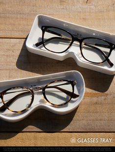 two glasses sitting on top of a white tray next to each other in front of a wooden table