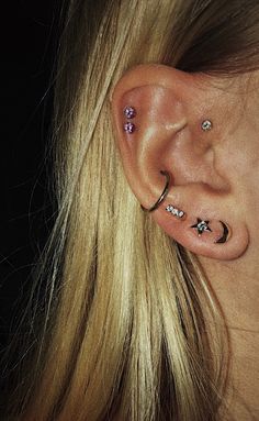 a close up of a person with ear piercings on their ears and behind the ear