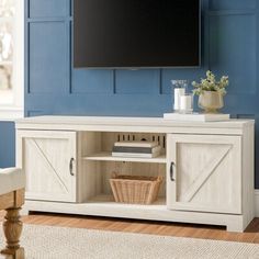 a flat screen tv mounted to the side of a wooden entertainment center in a living room