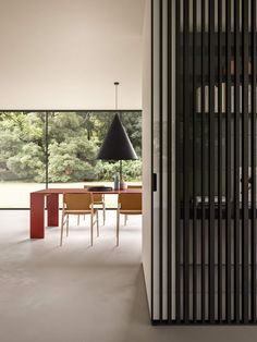 a dining room with a table and chairs next to a large glass window that looks out onto the outdoors