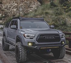 a gray toyota truck driving down a bridge