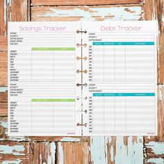 a planner with the words savings tracker and debt tracker written on it, sitting on top of an old wooden door