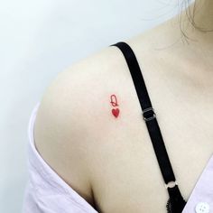 a woman with a red heart tattoo on her back shoulder and chest, wearing a black choker