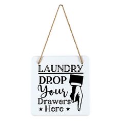 a white sign hanging from a rope with the words laundry drop your drawers here on it