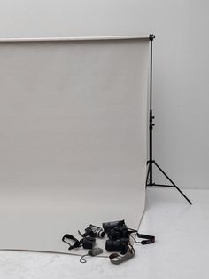 an empty photo studio with white backdrops and camera equipment on the floor in front of it