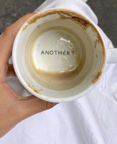 a person holding a coffee cup with the word another on it in their left hand