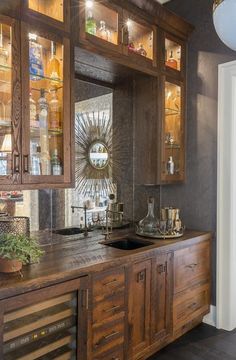 a kitchen with wooden cabinets and glass front cupboards on the wall, along with a potted plant