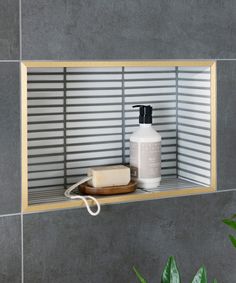 a bathroom shelf with a soap dispenser on it and a wooden cutting board