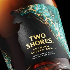 a bottle of two shores gold rum on a black background with an orange and blue swirl