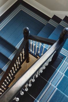 a stair case with metal railings and blue carpeted flooring in a house