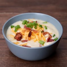 a bowl of soup with bacon, cheese and green onions