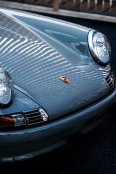 the front end of a blue porsche sports car