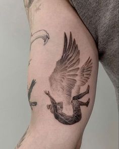 a man with a tattoo on his arm holding a bird and two birds in the air