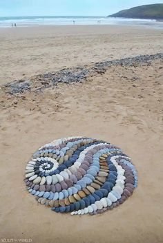 a circular rug made out of rocks on the beach