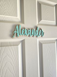 the name alesander is hanging on a door