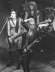 the runaways performing on stage with their guitars