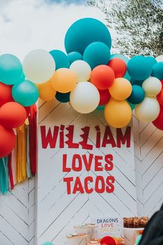 balloons and tacos are on display in front of a sign that says william loves tacos