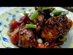 a plate topped with meat covered in sauce and vegetables