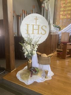 a table with flowers and a sign that says ths on it in front of a pipe organ