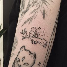 a person with a tattoo on their arm has a cat and dog sleeping on a tree branch