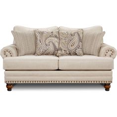 a white couch with pillows on it and some wood trimming around the armrests