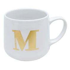 a white and gold mug with the letter m on it