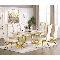 a white and gold dining room set with chairs, table and clock on the wall