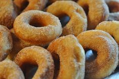 a pile of sugared donuts sitting on top of a table