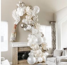 a living room filled with white balloons and a fire place in front of a fireplace