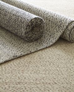 a rolled up rug on top of a floor next to a roll of carpeting