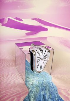 a glass box with a clock in it sitting on top of a rock and sand dunes