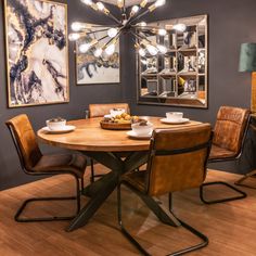 a dining room table with chairs and a chandelier hanging from the ceiling above it