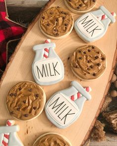 cookies decorated with frosting and chocolate chips on a wooden platter that says milk