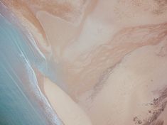 an aerial view of sand and water on the beach