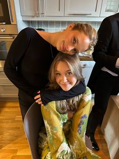 two women are posing for a photo in the kitchen with their arms around each other