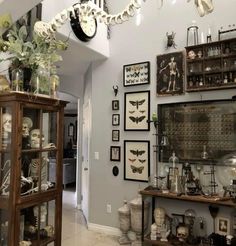 a living room filled with lots of furniture and pictures hanging on the wall above it