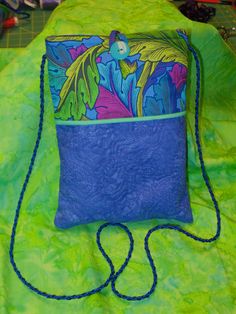 a blue and green purse sitting on top of a table