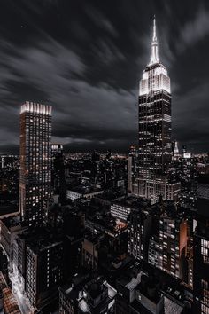 an aerial view of the empire building in new york city at night with dark clouds