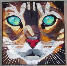 a painting of a cat's face with blue eyes