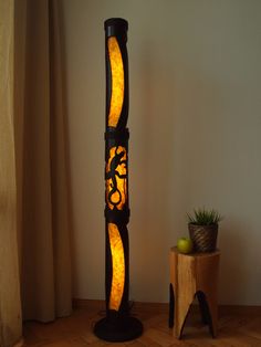 a lamp that is sitting on top of a wooden table next to a potted plant