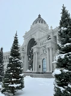 a large building surrounded by snow covered trees