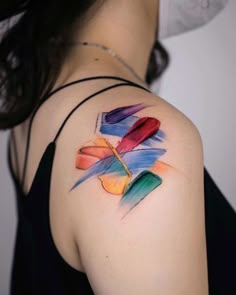 a woman's shoulder with colorful watercolors on her left arm and chest